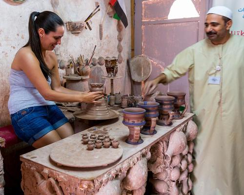 An Islamic potter teaching a female tourist making ceramic pots in Heritage villages in Abu Dhabi, United Arab Emirates