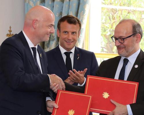 FIFA president Gianni Infantino (left) and AFD chief executive Remy Rioux (right) sign agreement at a ceremony attended by French President Emmanuel Macron (middle)
