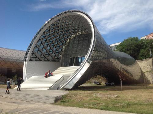 Two abstract soft-shaped elements connect together as a singular funnel-shaped silver structure / Studio Fuksas