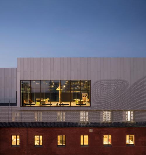 Existing brickwork, perforated aluminium panels and exposed glass have been combined for the exterior / Adam Mørk