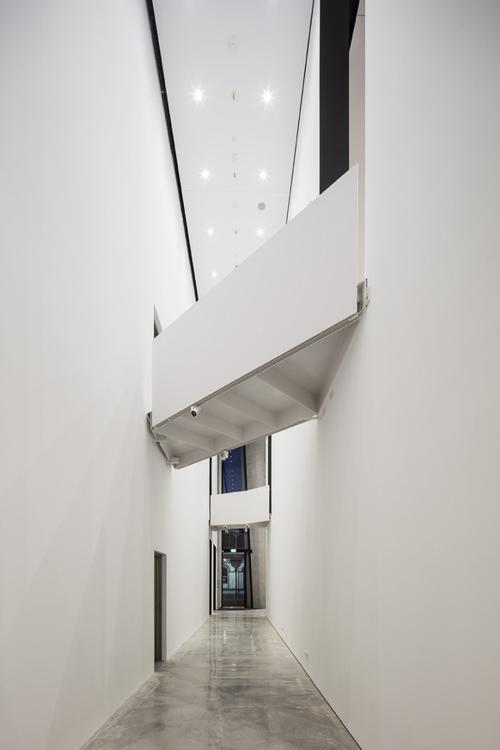 Large voids connected by ramps or bridges create a complex interior spacial sequence / Patterson Associates