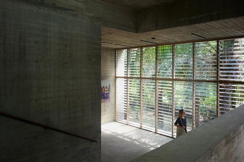 A large floor-to-ceiling window at one end allows natural light into the space / Julien Lanoo