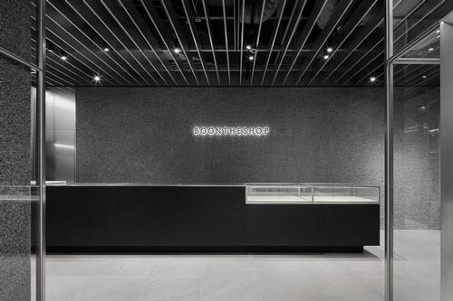 A minimalistic palette of grey concrete and metallic fixtures allows the items displayed to speak for themselves