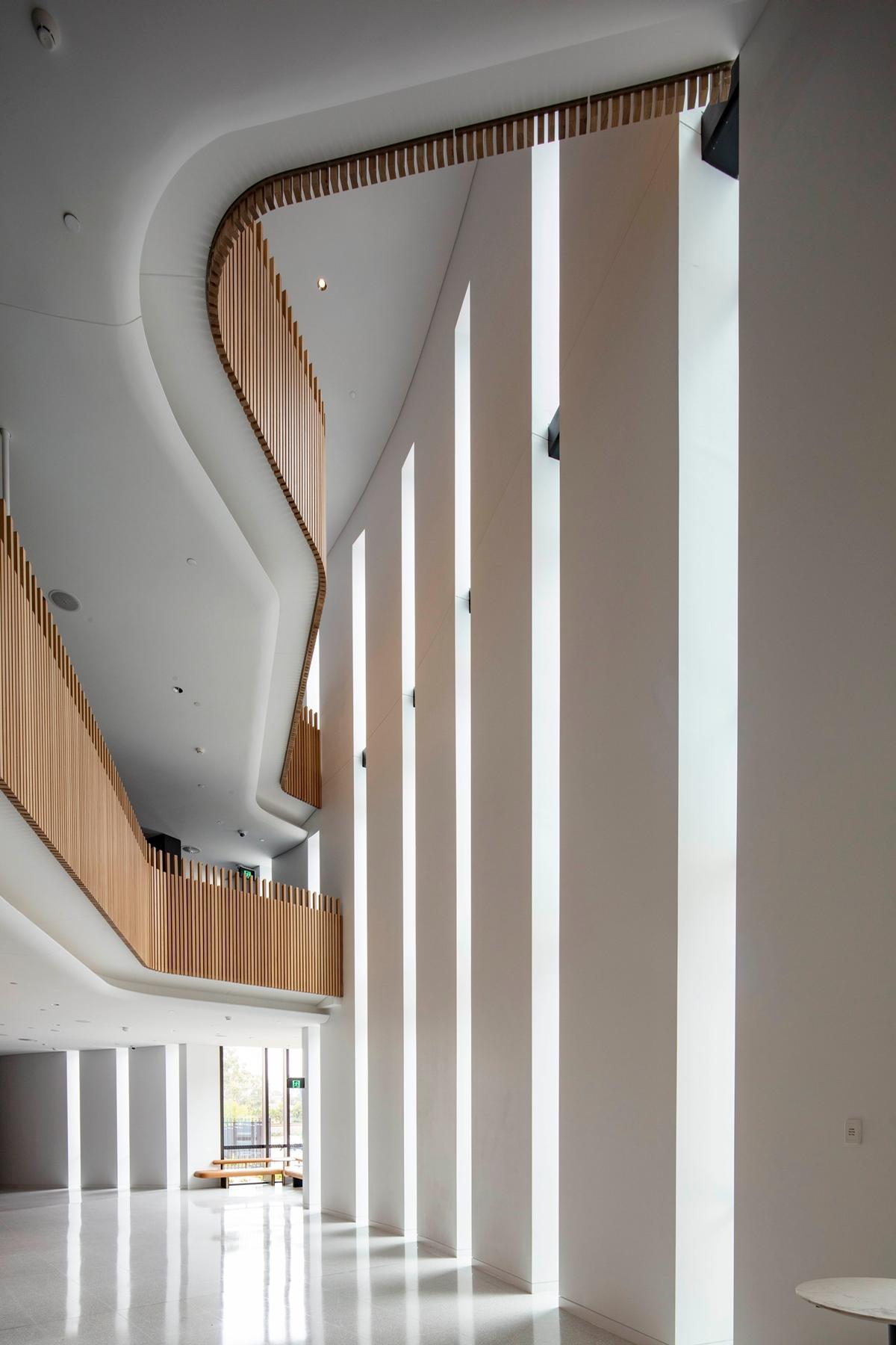 Natural light floods in through tall openings in the building's envelope / John Gollings