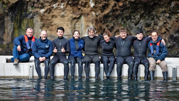 James Burleigh (left) and the Merlin team celebrate with John Bishop during the filming of the ITV documentary