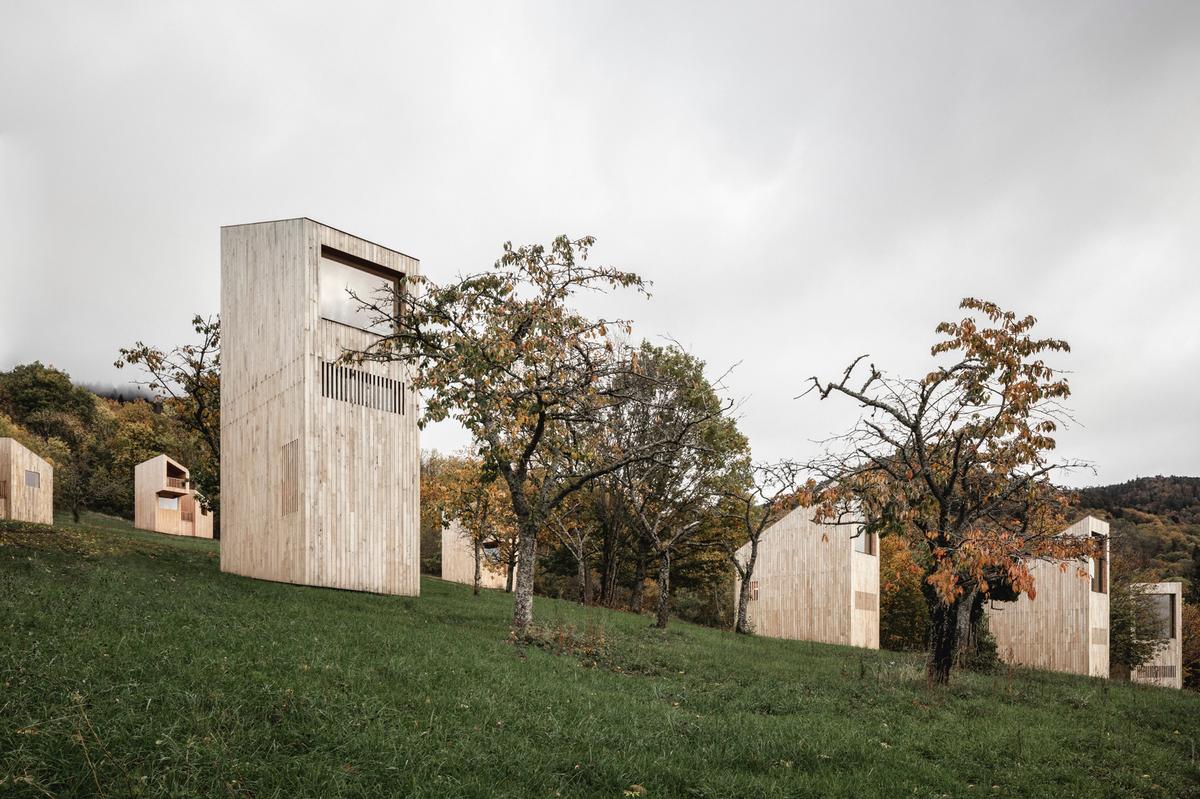 Amidst the trees, natural hedges and wild grasses, four different sizes of cabin dot the hillside / Florent Michel @11h45, Yvan Moreau