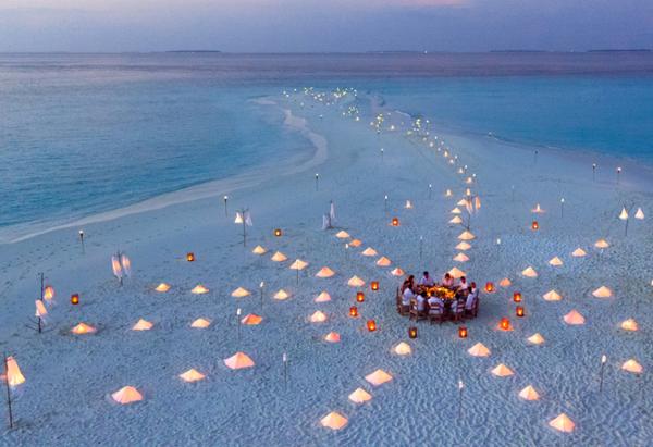 A sandbank dinner, enjoying a spectacular Maldives sunset at sister property, Soneva Fushi / photo: soneva fushi