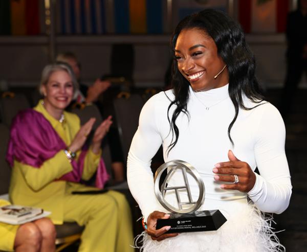 Biles received a summit award for her work in mental health / photo: Global wellness summit 2023