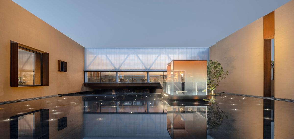 Studio A+ designed the hotel with a Zen-inspired orange glass pavilion suspended over water / Archi-translator