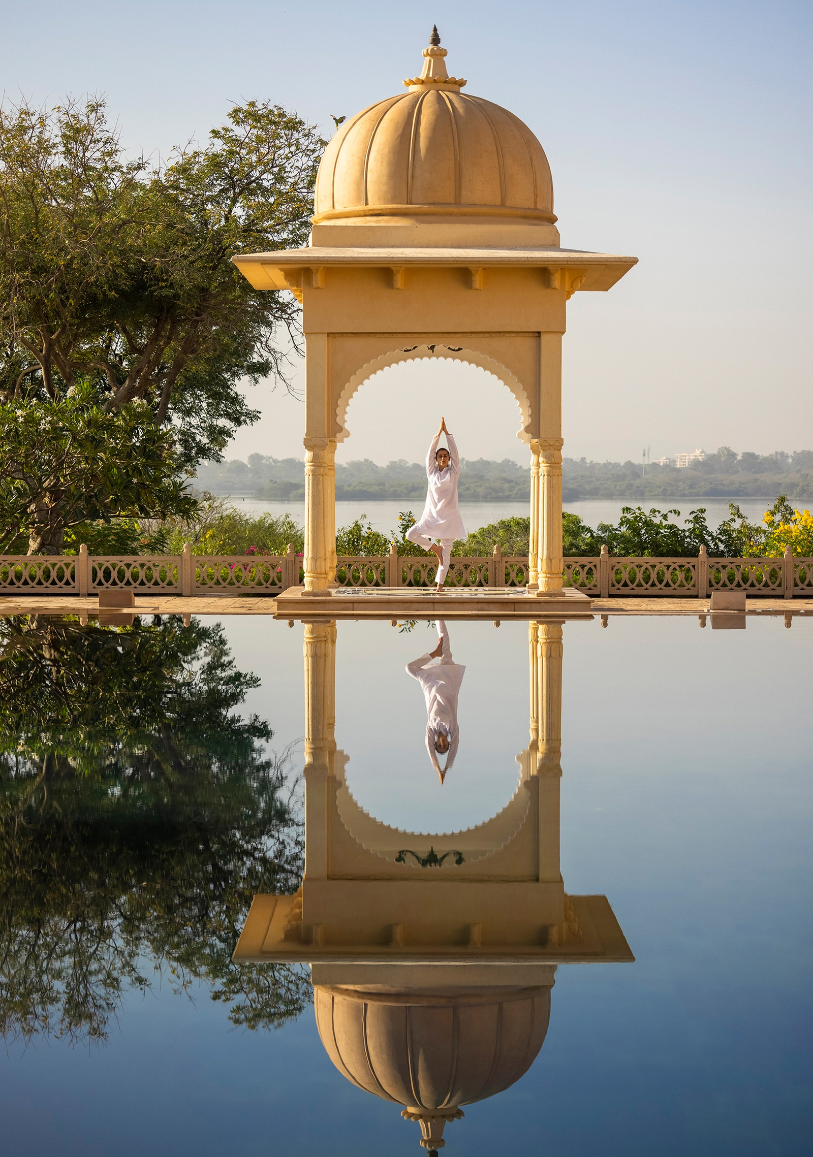 Woman in a yoga pose reflected in pool
