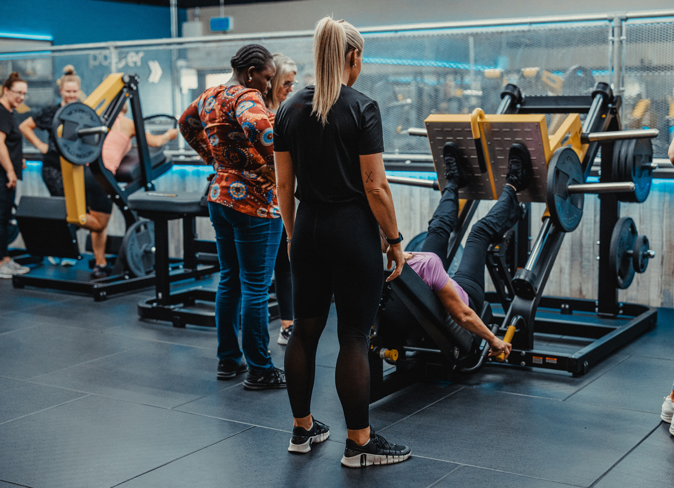 Women and instructor using gym equipment