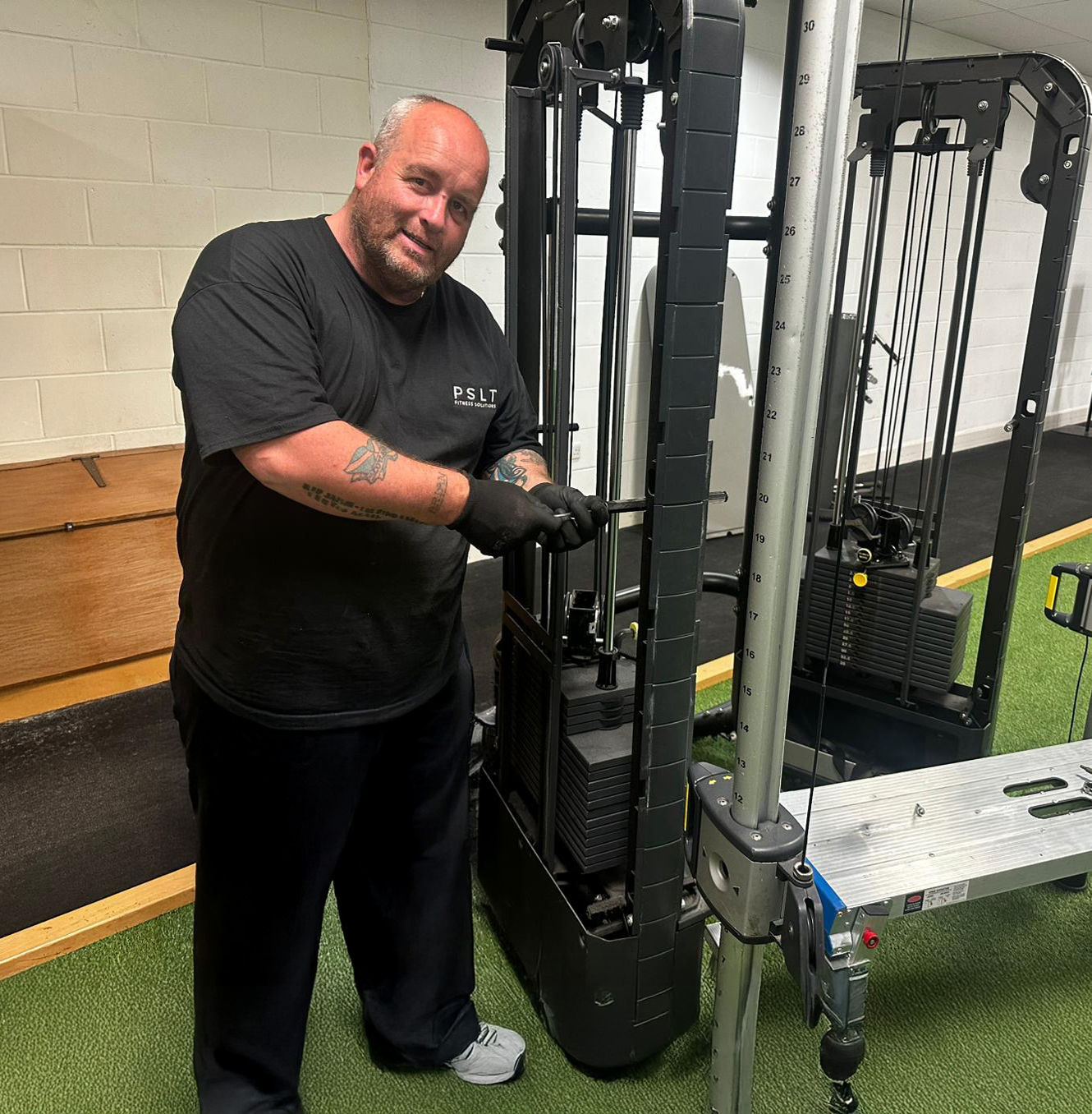 Man from PSLT checking gym equipment