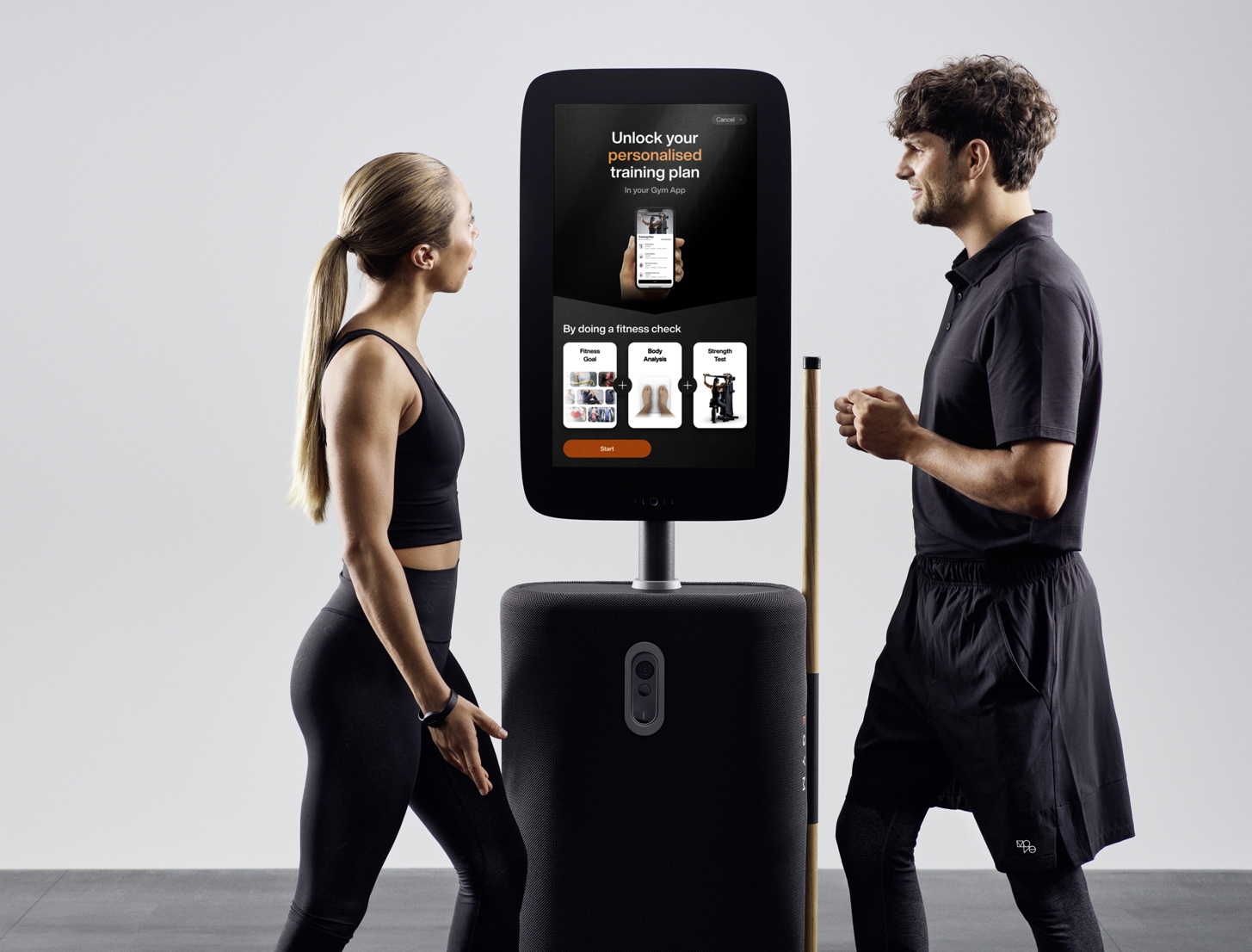 Man and woman with large screen EGYM device