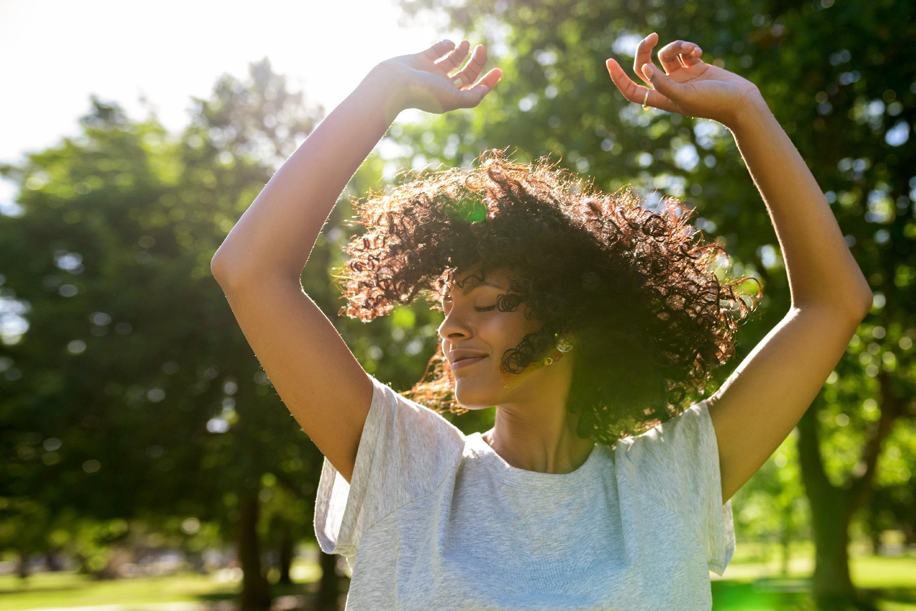 Woman with arms up in the sun