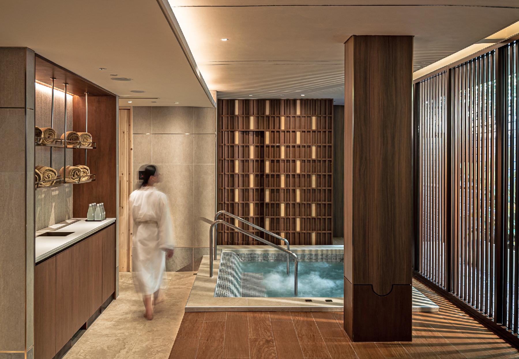 Woman in robe next to jacuzzi