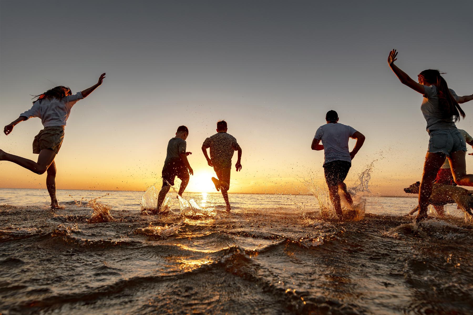 People running into the sea