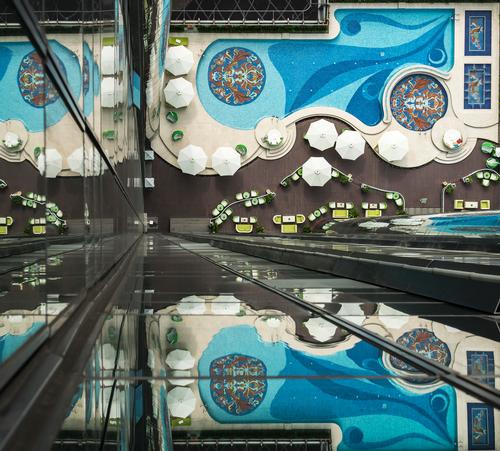 The swimming pool, located on an open-air deck, includes mosaic tile artistry by Sicis, and an underwater sound system / Reverie Saigon
