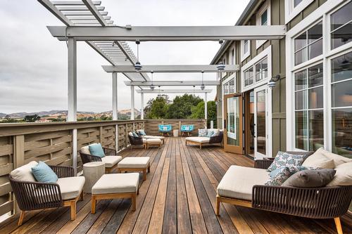 The private outdoor relaxation deck mirrors the entrance with a wisteria covered trellis, central water element, and contemporary chaise lounges