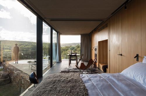 The main space contains the bedroom, living and dining room, which opens fully onto the landscape. / Leonardo Finotti