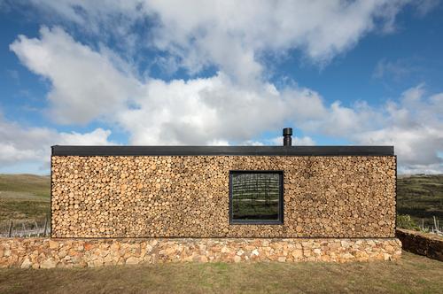 The rear of the cabins are composed by piles of wood logs, reminiscent of woodpiles typical of lifestyles in natural settings. / Leonardo Finotti