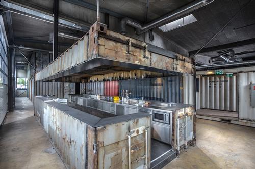 The containers have been converted for multifunctional use, with one being transformed into a bar