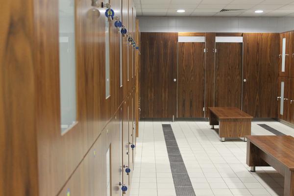 The changing rooms feature walnut veneer lockers with glass panels, and card locks for members
