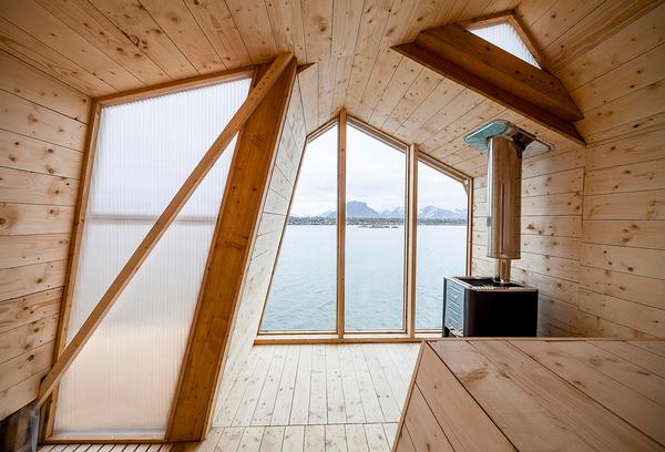 A woodburning stove provides heat for the building. The design is clean and simple, with larch used throughout