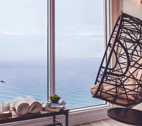 Pure Spa's relaxation room features hanging chairs and ocean views / Pelican Grand Resort