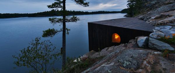 Charred cedar was chosen for its natural, weathered appearance. The sauna juts into the lake