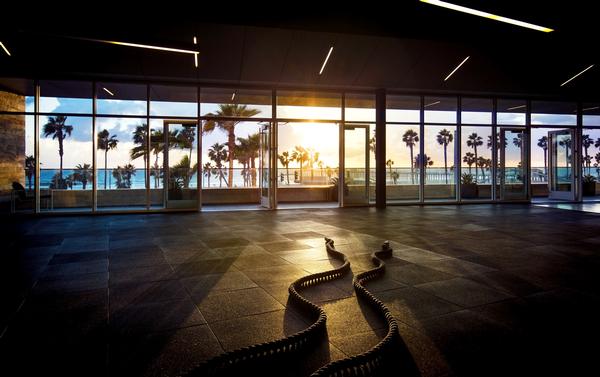 Floor to ceiling windows frame the view of the beach at Equinox Huntington in California