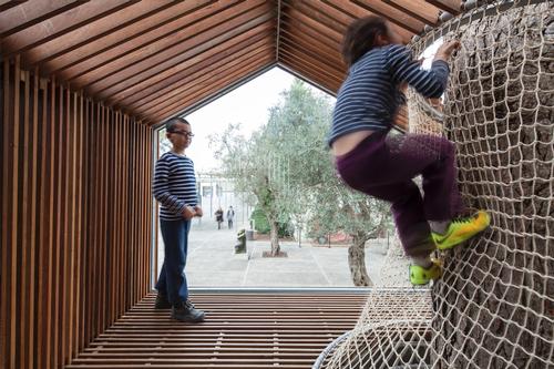 Wooden slats give the effect of transparencies across the structure / Amit Geron