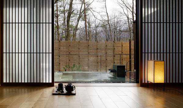 Large windows and folding doors provide views of the terraces and forest outside