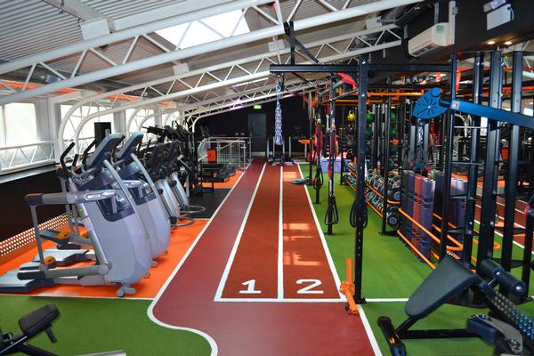 The functional floor is on a separate level from the nightclub-feel gym, with a 21-foot custom-built rig standing alongside a sprint track