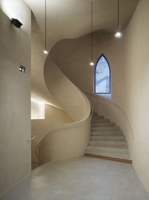 A huge spiral staircase links the new building and tunnel / Ruedi Walit