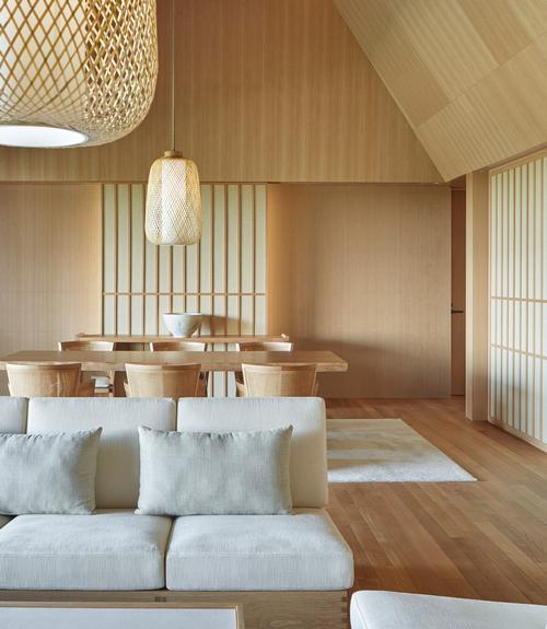 Custom-made furniture ensures a harmony between architecture and design, and incorporates white oak coffee tables, sofas and armchairs with neutral fabric tones