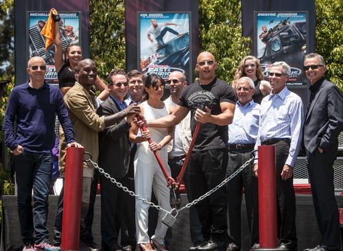 Fast & Furious cast members, including Vin Diesel and Michelle Rodriguez, cut the chain to open the Supercharged ride / Universal Studios