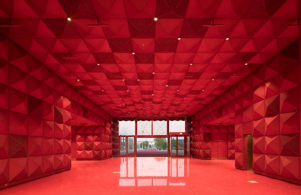The recently opened Ragnarock rock museum in Roskilde, Denmark features a gold studded façade, bold red interiors and a cantilevered auditorium 