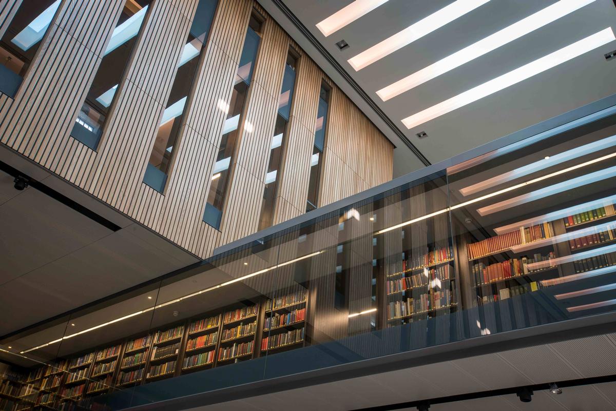 The library's glass mezzanine forms a direct visual relationship with the books / John Cairns