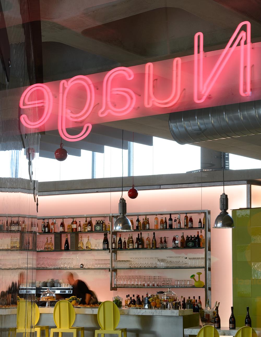 The café bar area features a neon pink sign and a range of lime green furniture and tiling. Starck aimed to create a light, airy feel across the health club, while adding a sense of fun