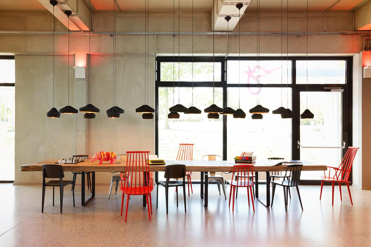 Bare walls and raw materials are fused with ambient lighting and colourful props / Moxy Berlin