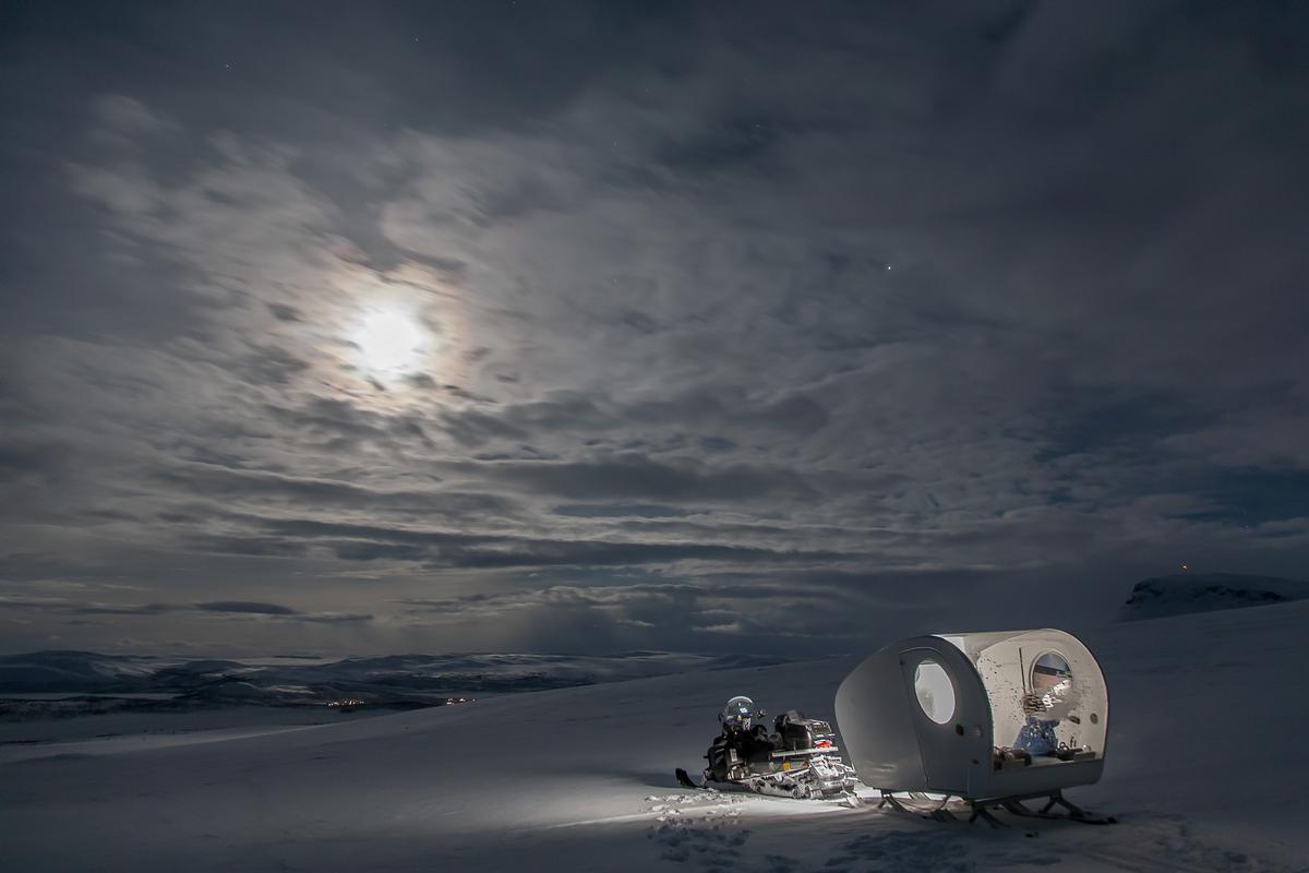 The sled is mounted on the back of a snowmobile and towed deep into the Arctic wilderness, with guests then left to soak up the Arctic night sky in isolation / Kilpissafarit