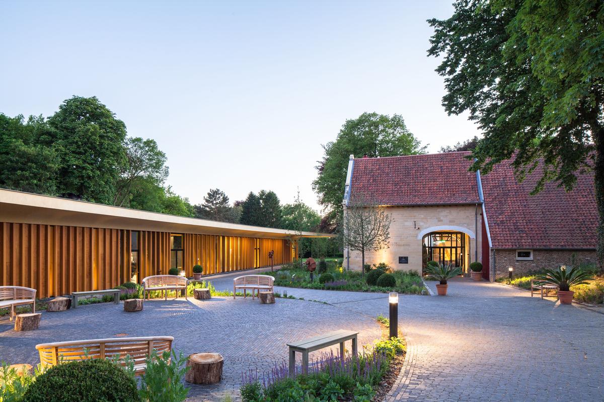 An intimate 'village square' has also been created between the pavilion and the manor farm that forms an outdoor extension of the foyer / Mecanoo architecten