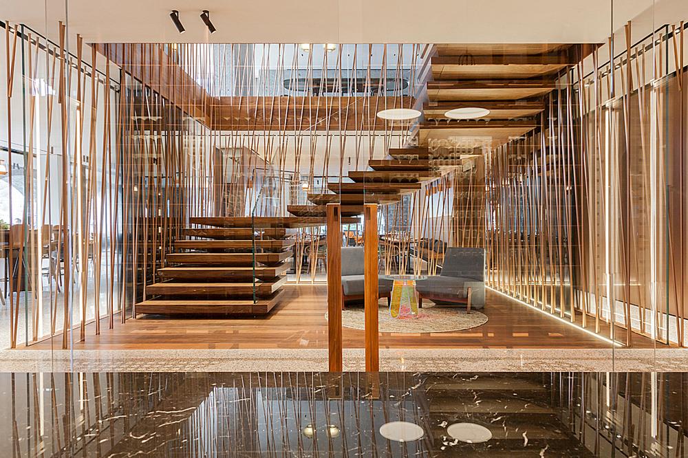 The hotel’s central staircase features stacked steps that appear to float. It is made from walnut and bronze