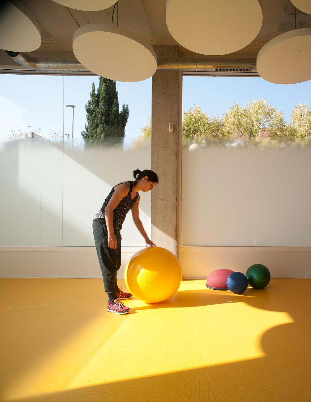 Bold splashes of colour have been used throughout the gym, contrasting with the white walls and exposed cement. Large windows allow natural light to flood the space