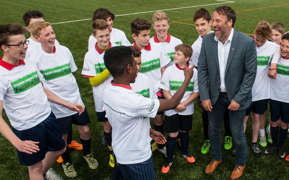 Former Arsenal player Paul Merson shares a joke as he cuts the ribbon on another facility