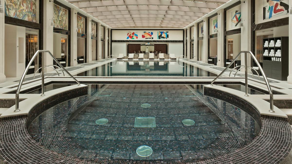 The pool area, decorated in constructivist style, offers its guests an adjoining heated whirlpool and a poolside Amnis Café serving a superfoods menu. / Four Seasons