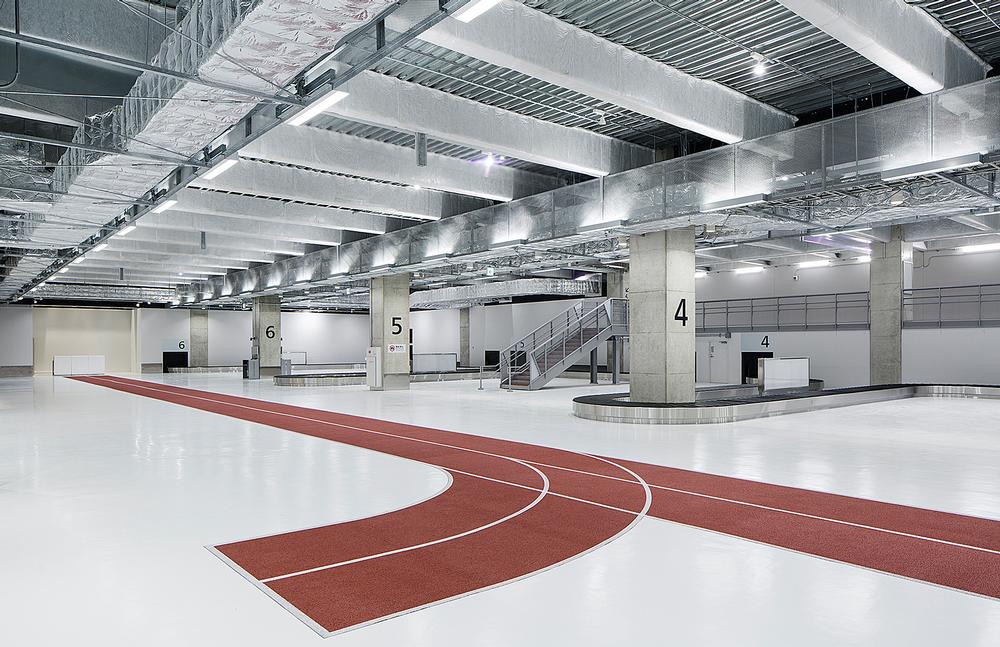 The running tracks in the airport are colour coded: red for arrivals and blue for departures. White stenciled symbols direct passengers to the correct part of the building / Photos: Kenta Hasegawa