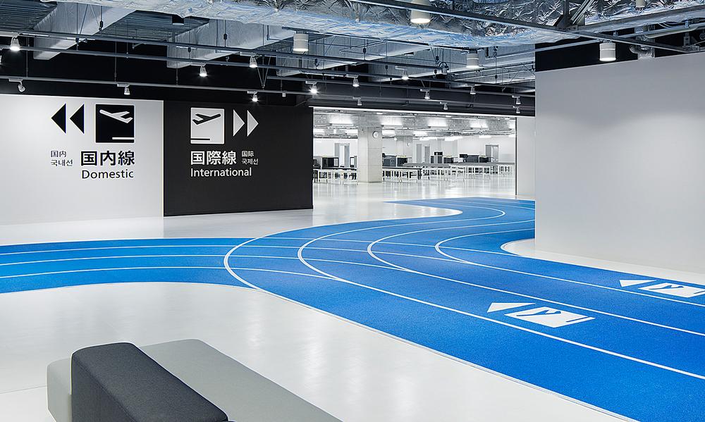 The running tracks in the airport are colour coded: red for arrivals and blue for departures. White stenciled symbols direct passengers to the correct part of the building / Photos: Kenta Hasegawa