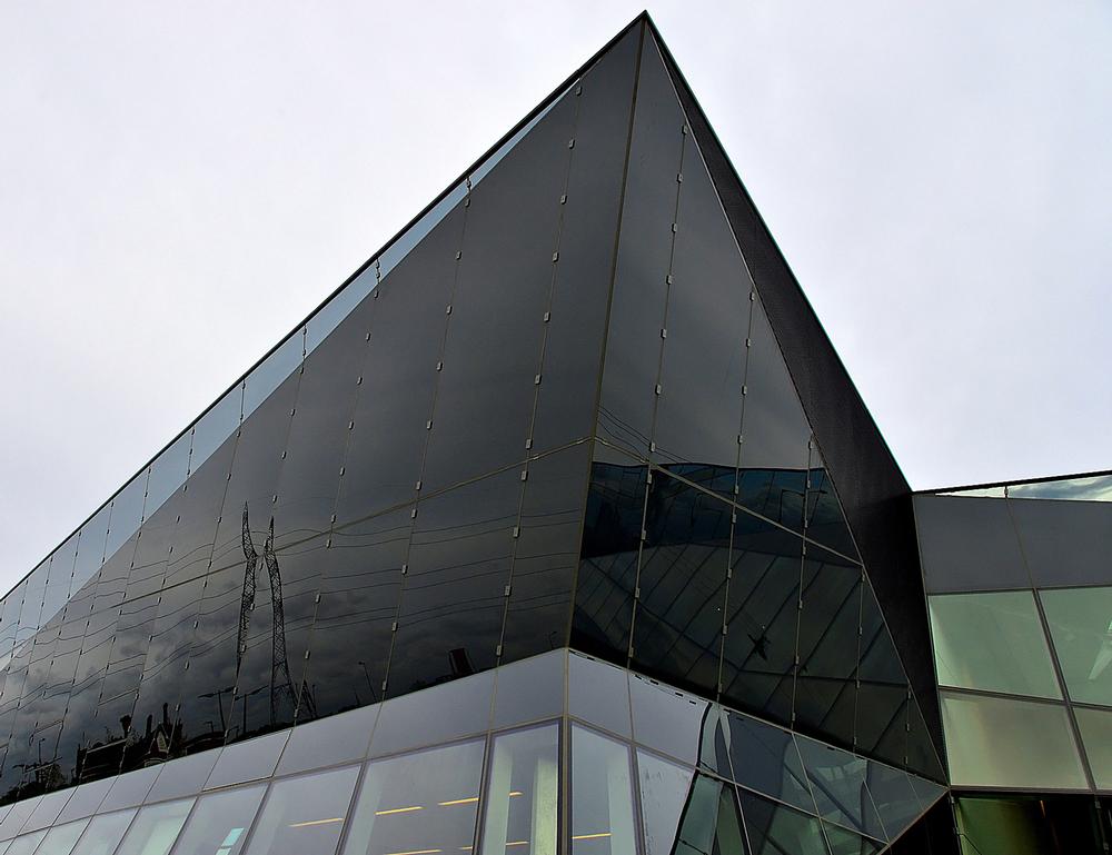 The building's angular lines contrast with the curved 02 Arena beyond