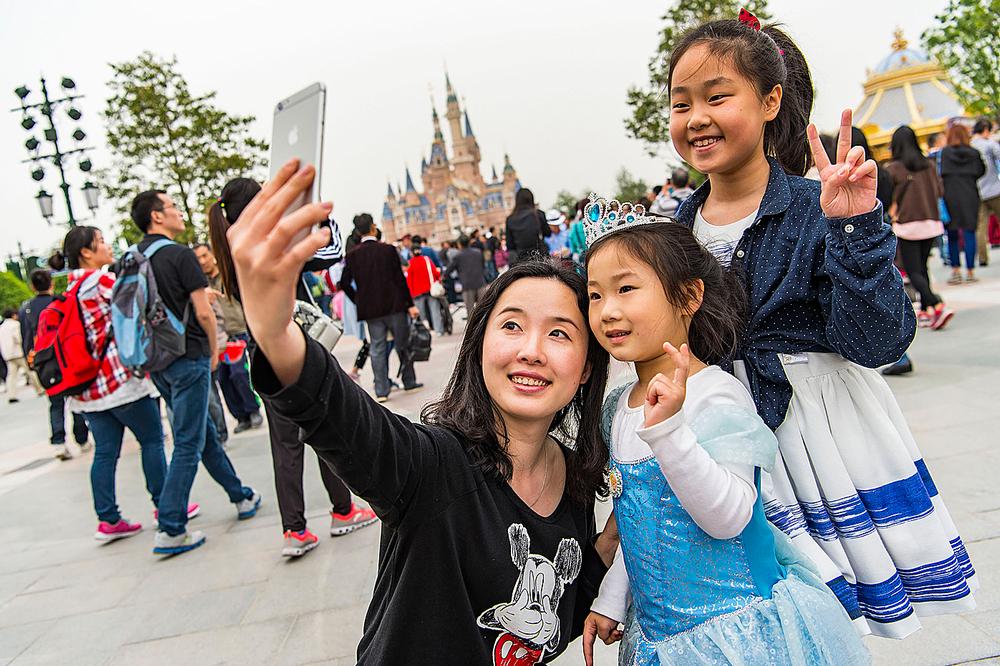 Visitors take a selfie on Mickey Avenue